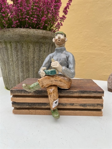 Keramikfigur - mand på træklods