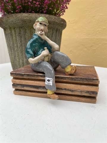 Keramikfigur - mand på træklods